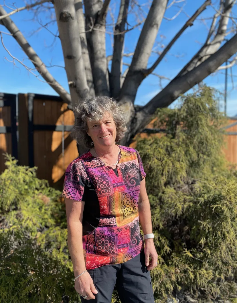Heather smiling standing outside in front of a tree